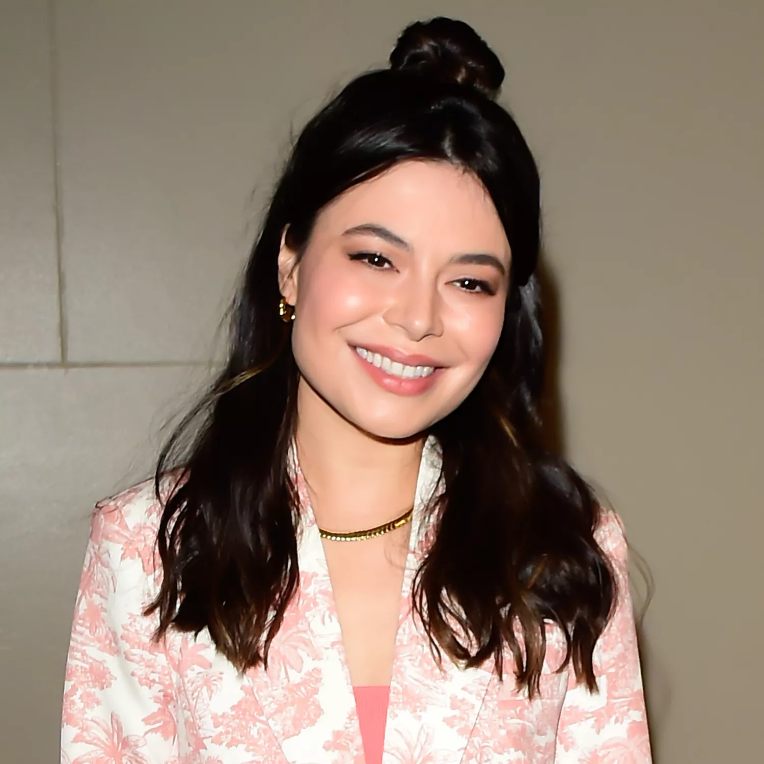 nagyított képe, amint Miranda Cosgrove mosolyog a kamerába fényes fekete hullámokkal, frufru kimaradt, és haja teteje enyhén visszahúzódott egy rendetlen kontyba a feje hátsó részén