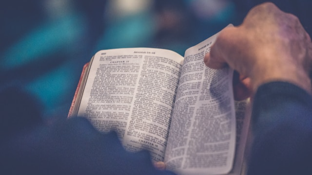 illusztráció valakiről, aki a Bibliát olvassa (unsplash.com/@rodlong)