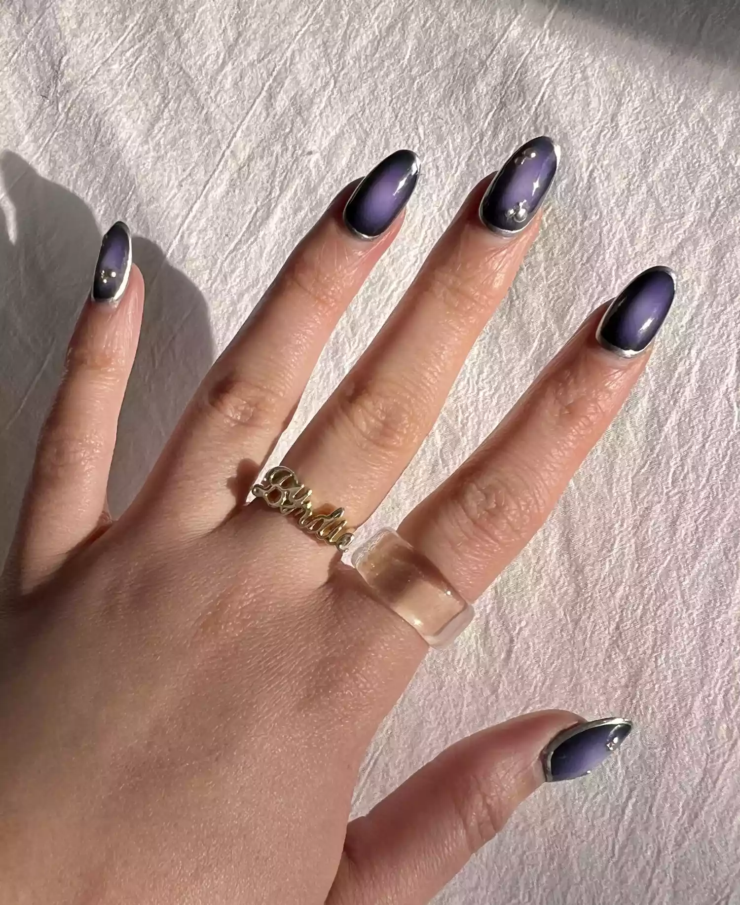 Lila árnyalatú aura manikűr króm részletekkel