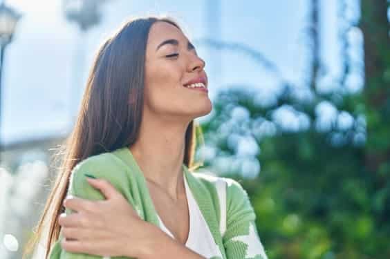 Nő mosolyogva, és átölelte magát