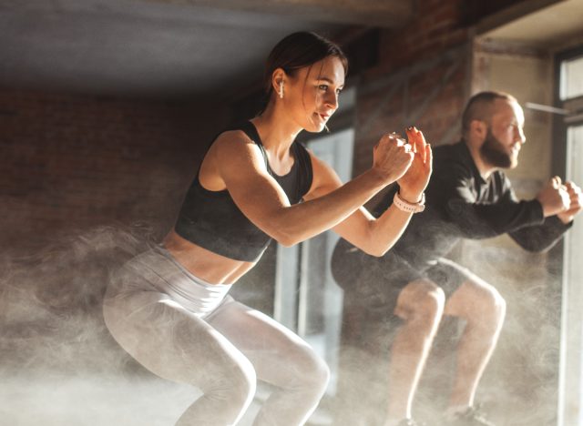 fitness duó ugró guggolást végez az edzőteremben