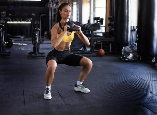 fitt nő kettlebell guggolást csinál