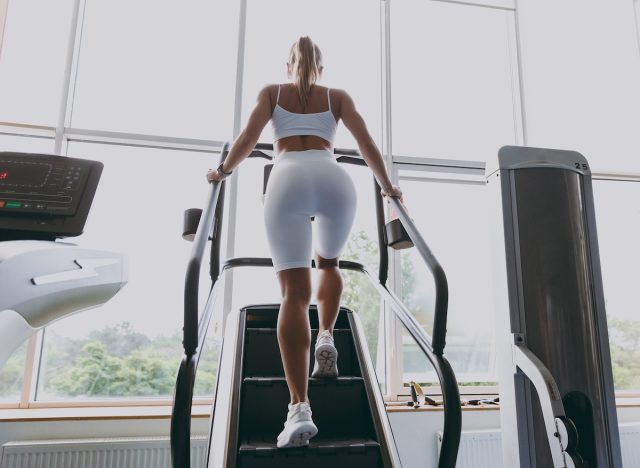 fitness nő StairMaster edzést az edzőteremben, hátulnézet