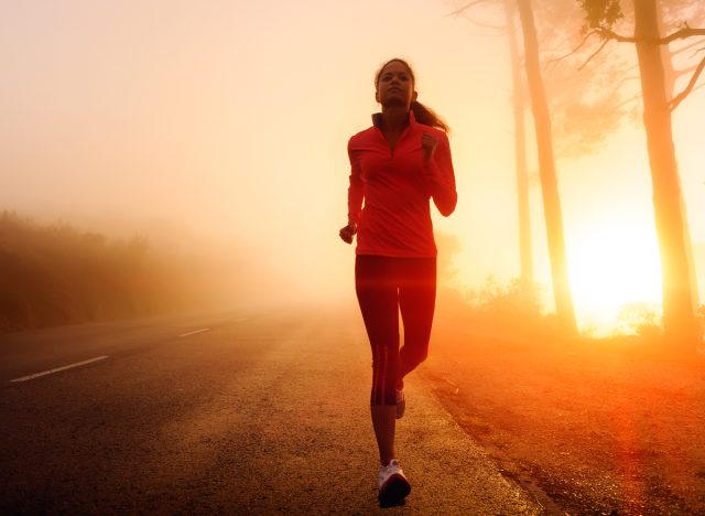 fitness nő fut kora reggel a szabadban, miközben felkel a nap