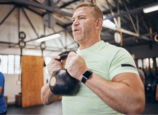 férfi kettlebellt emel, szabadsúlyos gyakorlatokat mutat be, hogy megszabaduljon egy apa hasától