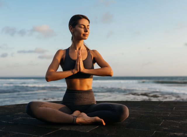 nő meditál a tengerparton, megbirkózik azzal, hogy elárulta egy legjobb barátja