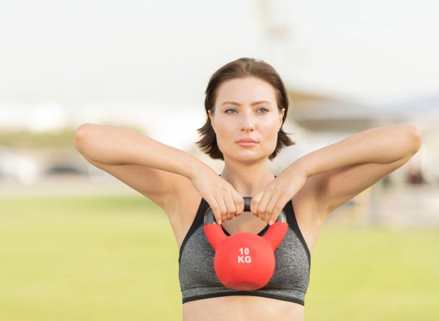 nő bizonyítja egyenes sor gyakorlatok kettlebell, hogy elveszítse váll zsír