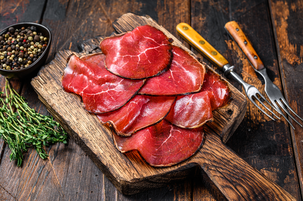 Több szelet bresaola egy fa aprítón