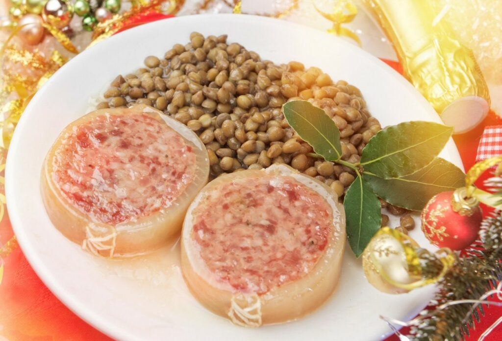 Cotechino con Lenticchie egy nagy fehér tányéron