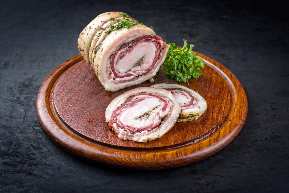 Pancetta egy fa aprítón néhány szelet salátával
