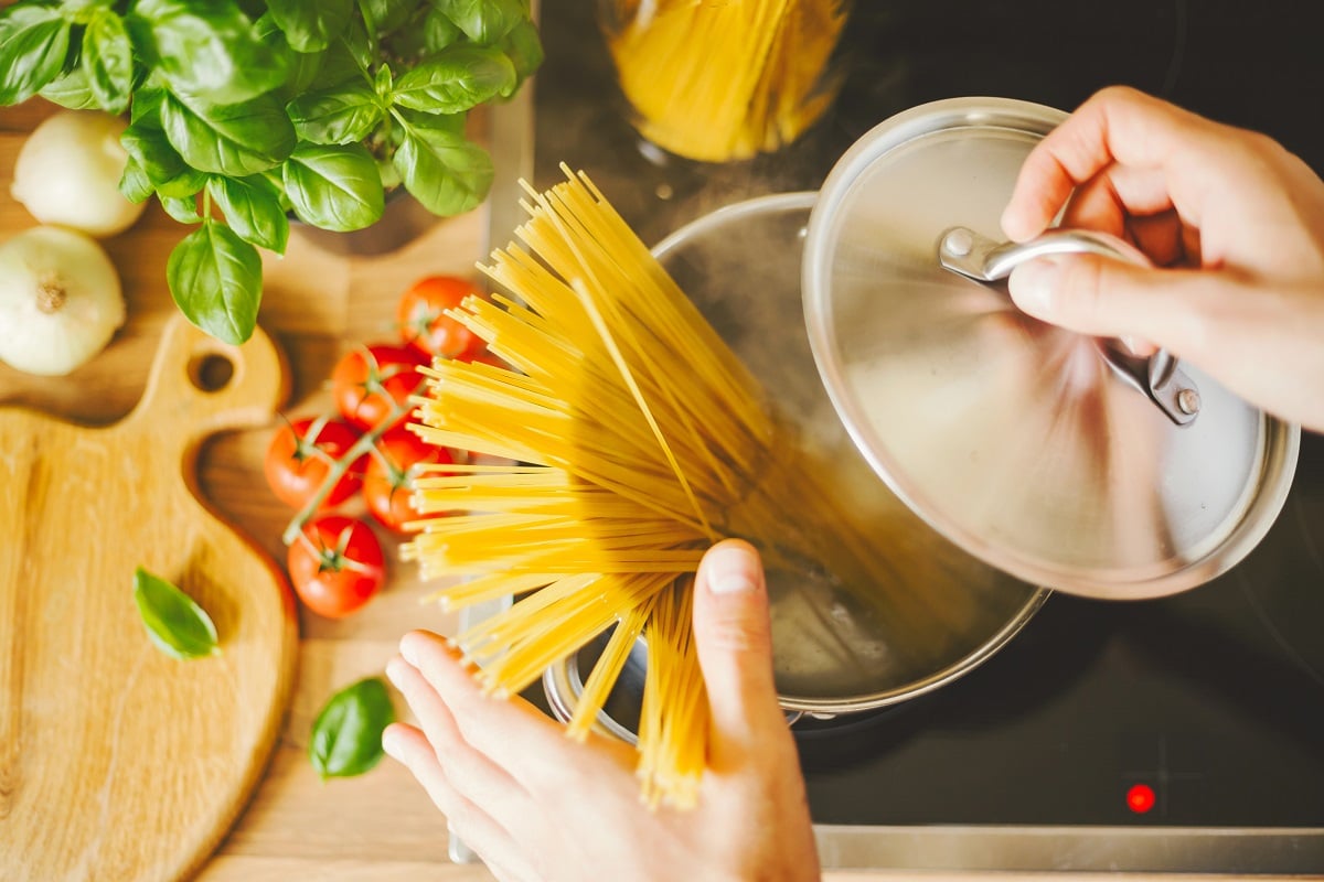 Egy fapult egy fazék forrásban lévő vízzel és tésztával, amely szemlélteti a tészta al dente főzését Egy fapult egy fazék forrásban lévő vízzel és tésztával, amely szemlélteti a tészta al dente főzését